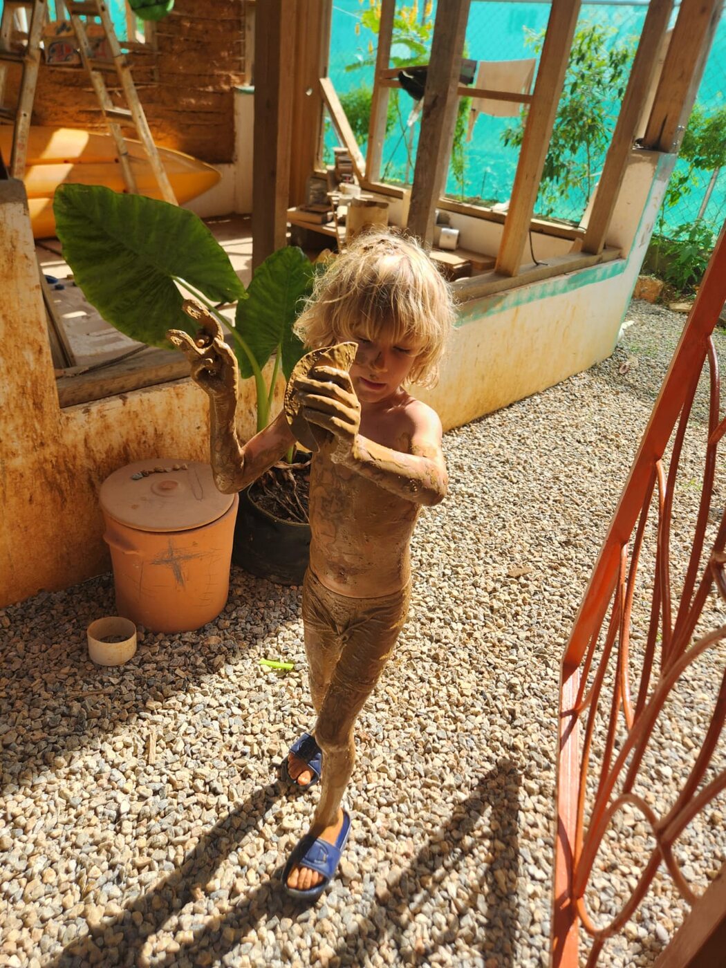 Niño cubierto de barro de pies a cabeza