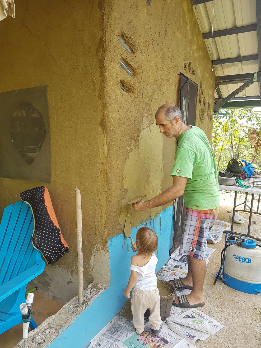 Ezequiel y Coa revocando una pared de tierra juntos, en Permachacra